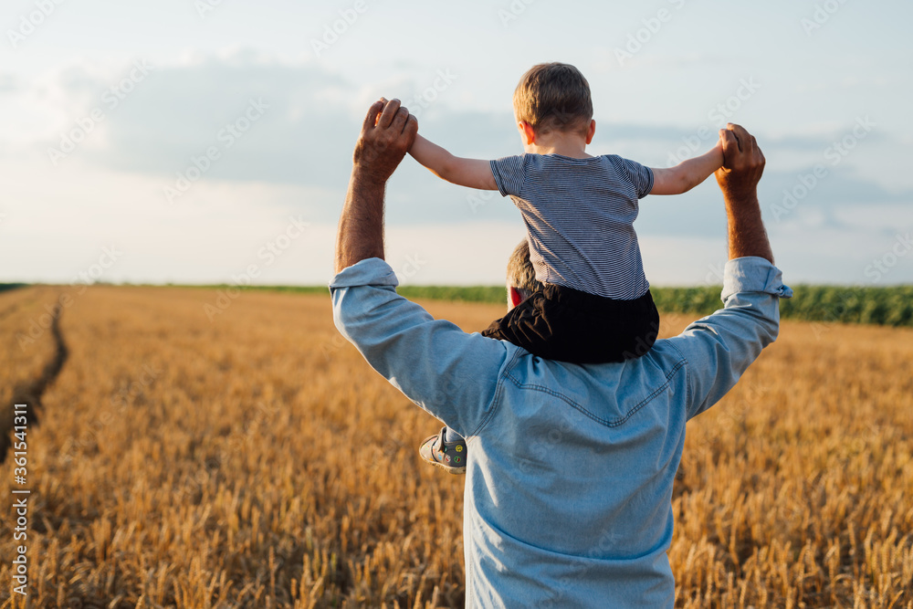 A father holds his son on top of his shoulders
